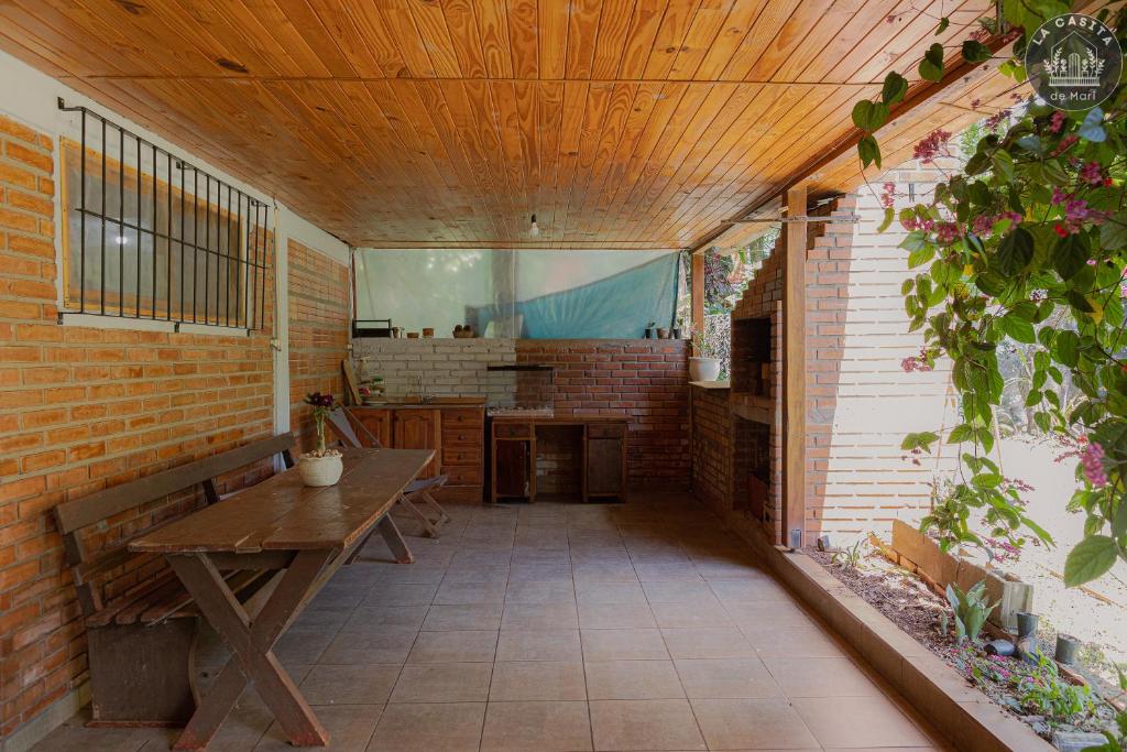 un patio al aire libre con mesa de madera y banco en La casita de Mari, en Ruiz de Montoya