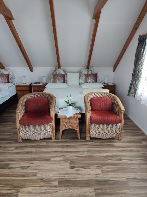 two wicker chairs and a table in a room at Whitianga Luxurious studio room in Whitianga