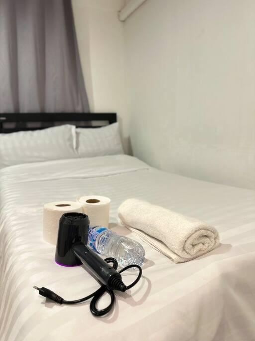 a white bed with a camera and towels on it at Chubbi 5 Room10 in Bang O
