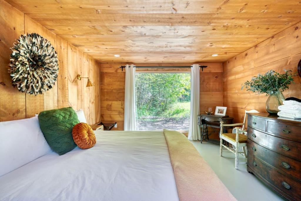 ein Schlafzimmer mit großem Bett und Fenster in der Unterkunft The Cottage at Highland Farms in Brightwood