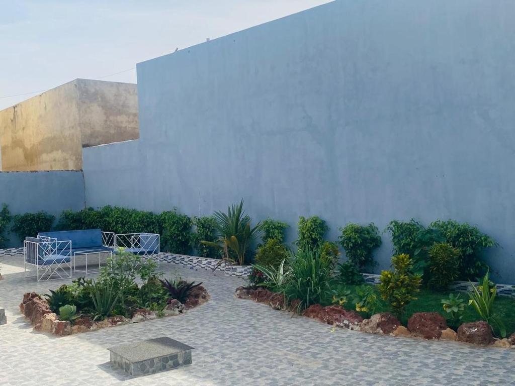a courtyard with plants and a blue wall at Senkeur in Sali Nianiaral