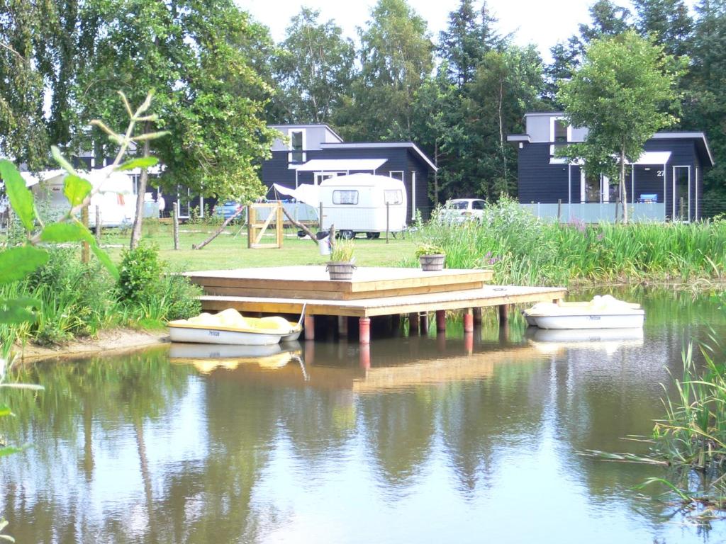 dos barcos están sentados en el agua cerca de un muelle en Asaa Camping & Cottages, en Aså