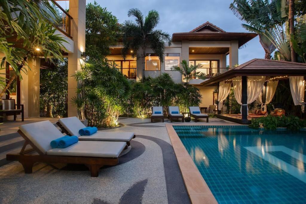 a villa with a swimming pool in front of a house at 4 Secluded Villas Private Resort in Nathon Bay