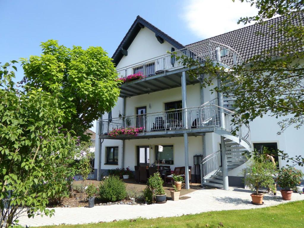 une maison blanche avec un balcon et des arbres dans l'établissement Werners Ferienwohnung, à Insul