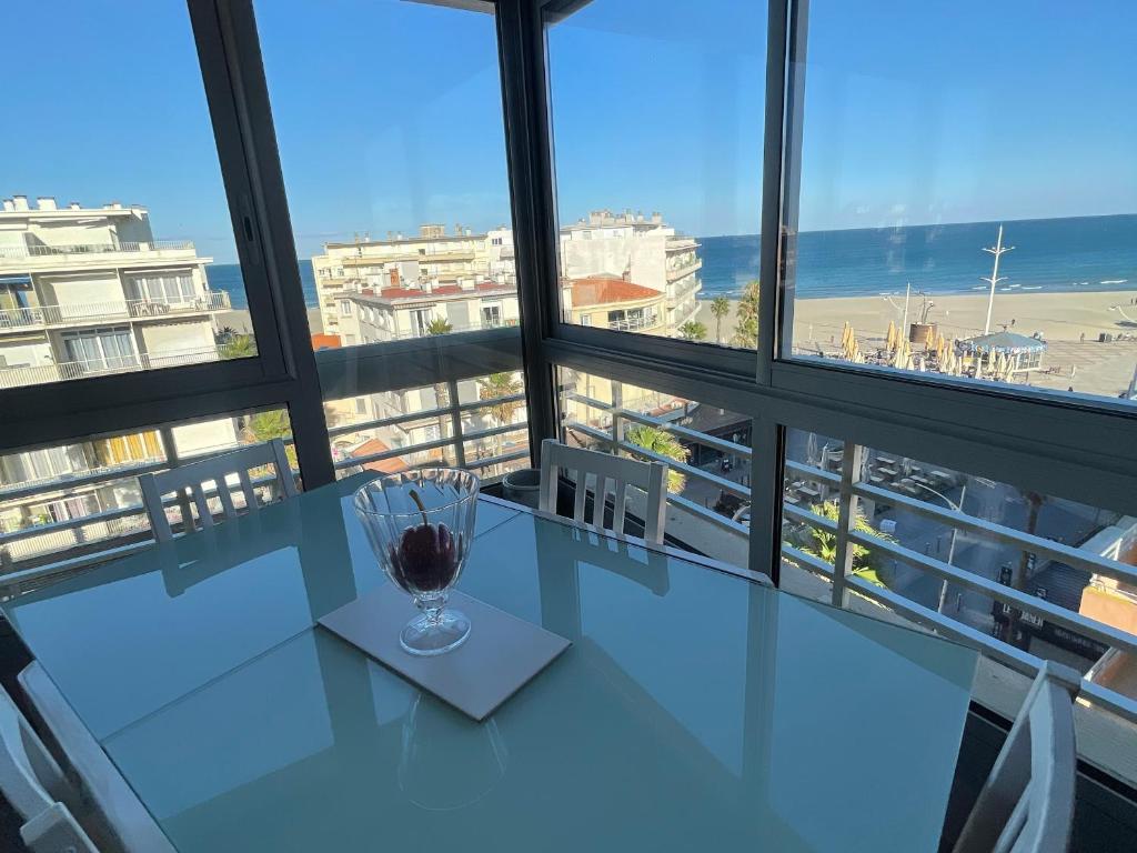 une table en verre dans une chambre avec fenêtre dans l'établissement Appartement 2P en bord de mer à Canet, parking inclus - FR-1-732-90, à Canet