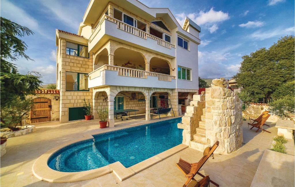 a house with a swimming pool in front of it at Nice Home In Trogir With House Sea View in Trogir