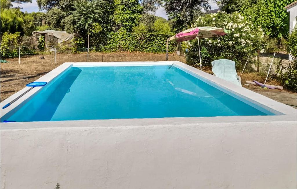 a blue swimming pool with an umbrella next to it at Lovely Home In Xativa-Almaseretes in Caserío Casa Sanchis