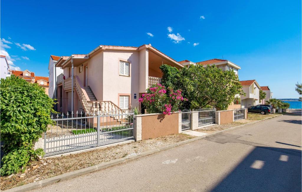 a house with a fence in front of a street at 2 Bedroom Awesome Apartment In Povljana in Povljana