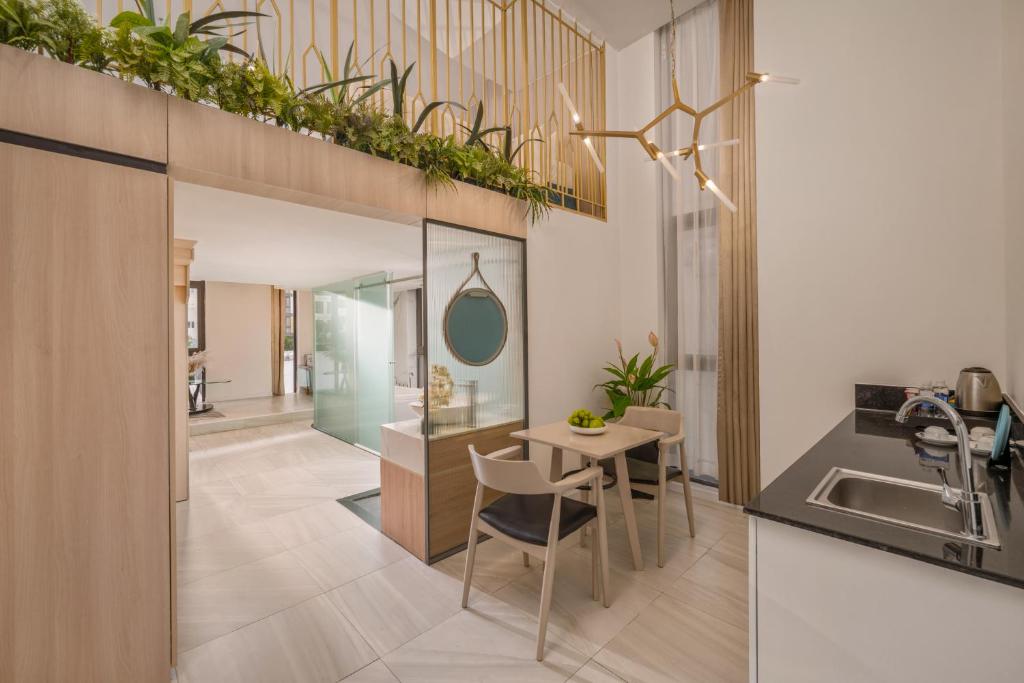 A compact in-room kitchenette and dining corner beside a glazed bathroom entrance.
