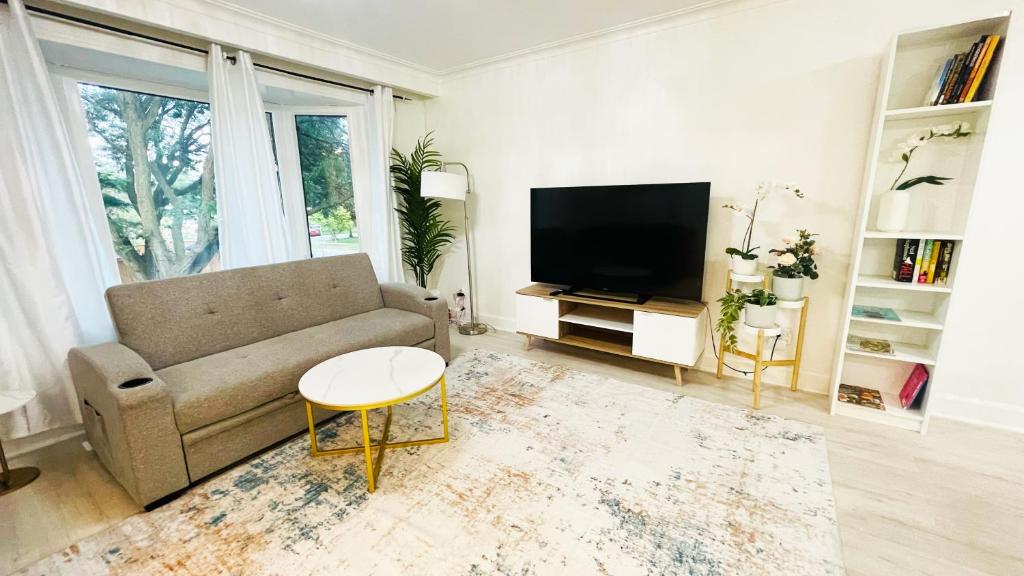a living room with a couch and a tv at Amazing Home Near Toronto Airport with 2 Parking in Toronto