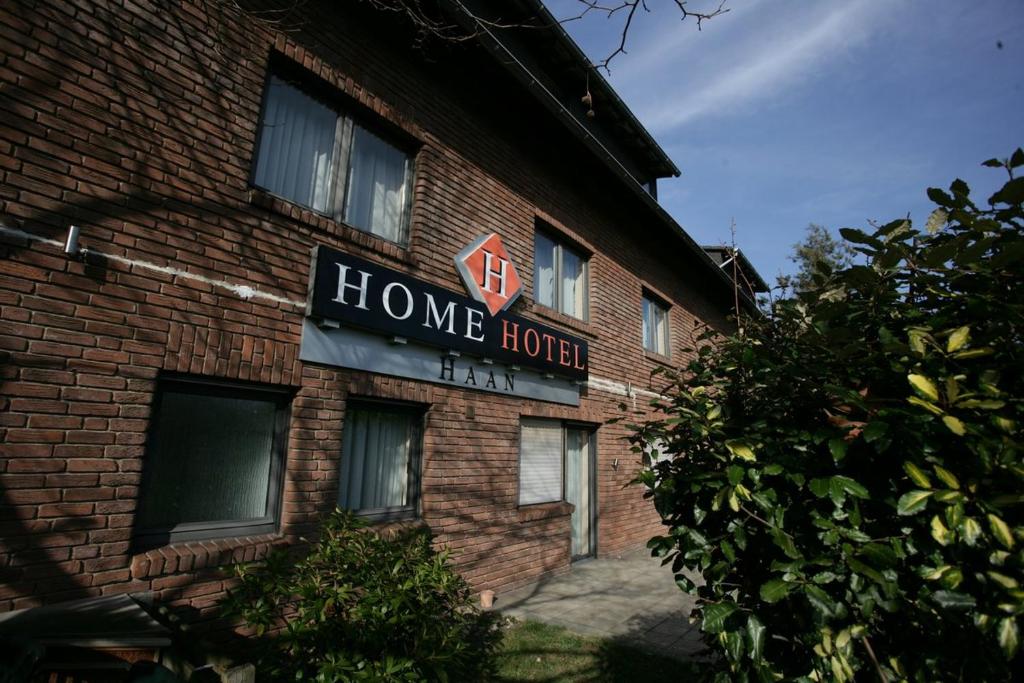 a home hotel sign on the side of a brick building at Stargaze Home Hotel in Haan