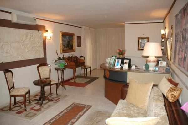 ein Wohnzimmer mit einem Sofa, einem Tisch und Stühlen in der Unterkunft Hotel Canusium in Canosa di Puglia