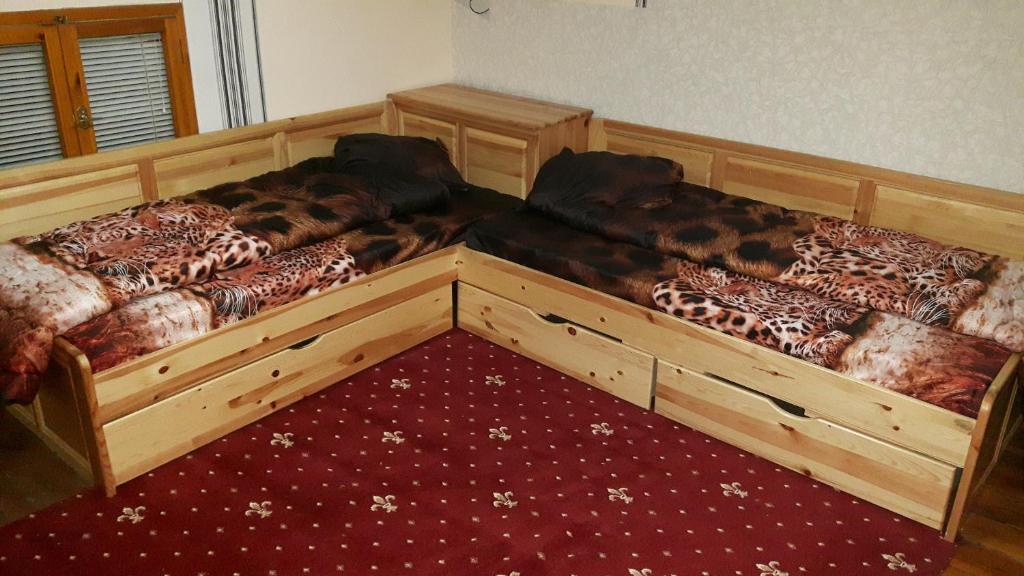 2 camas de madera en una habitación con alfombra roja en Hostel Alex 1, en Sofía
