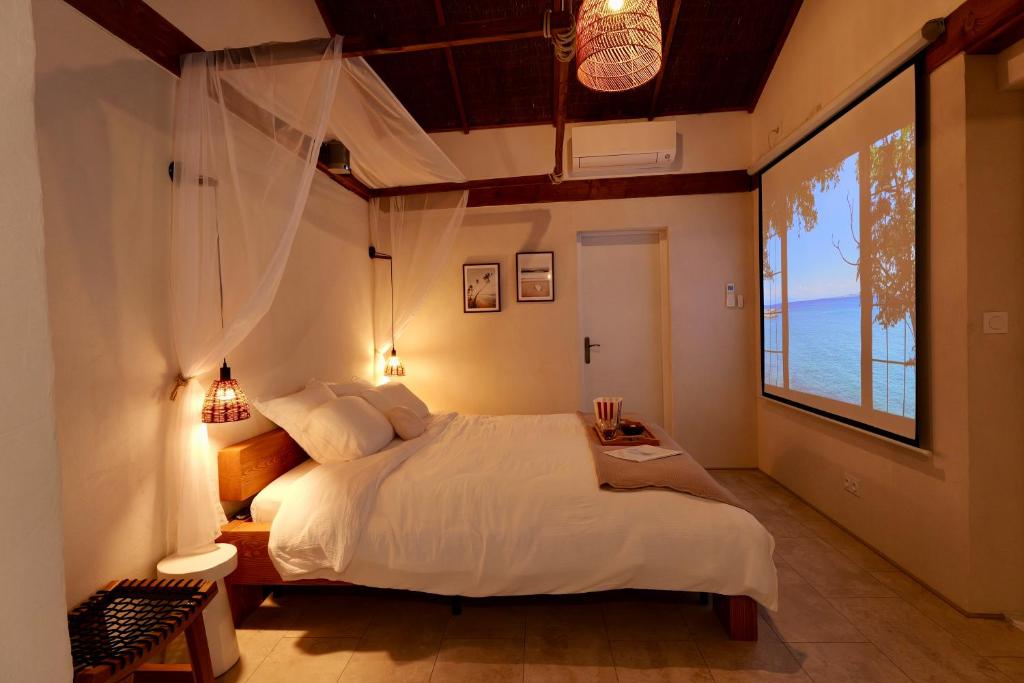 a bedroom with a bed and a large window at Love room Piccola casa, côté île in La Verpillière