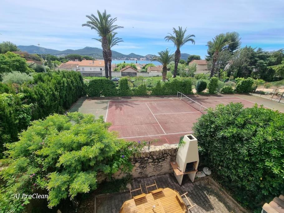 - une vue aérienne sur un court de tennis avec des palmiers dans l'établissement Armence, maison vue mer avec petit jardin et terrain de tennis - By AURAconciergerie, aux Lecques