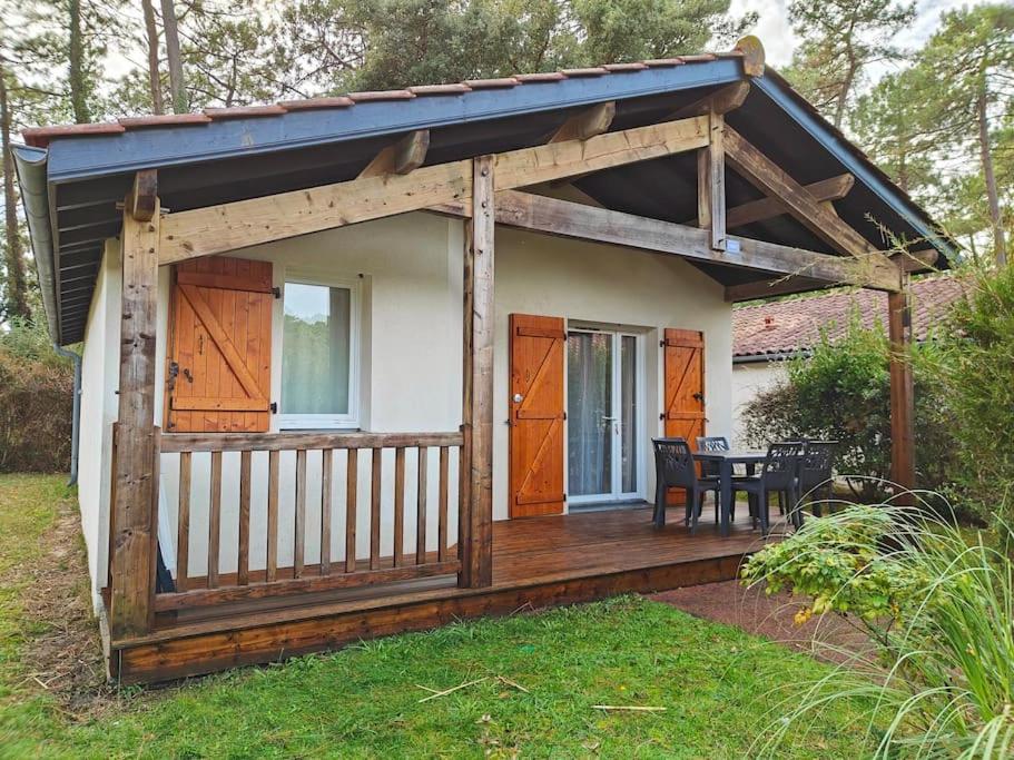 une maison avec une terrasse en bois et une table dans l'établissement Maison avec piscine, tennis, à Ondres