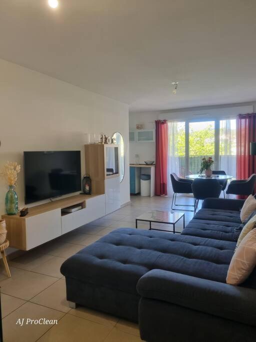 un salon avec un canapé bleu et une télévision dans l'établissement La Petite Cigale, grand balcon à 10min du Circuit Paul Richard et 15min de la mer - By AURAconciergerie, au Beausset