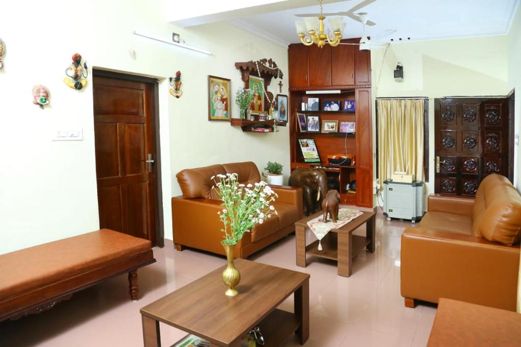 un soggiorno con divani e un tavolo di Jasmin Villa a Cochin