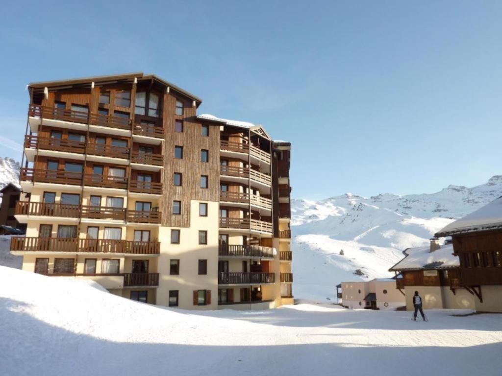 ein Gebäude im Schnee mit einer Person vor der Tür in der Unterkunft Reine Blanche Condo By AlpineStay in Val Thorens