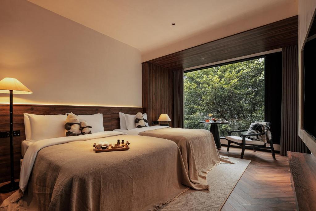 桂林Rong Unique Hotel-Banyan Lake Scenery的一间卧室设有两张床和大窗户