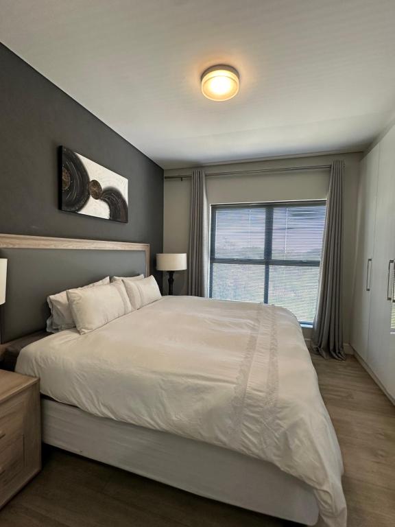 a bedroom with a large bed and a window at House of Grace with Backup power Next to OR Tambo in Kempton Park