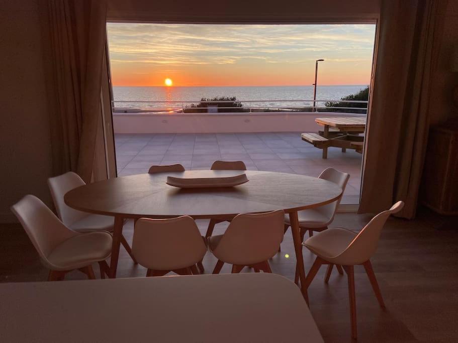 ein Tisch und Stühle mit Blick auf das Meer in der Unterkunft Villa face mer avec terrasse in Merlimont