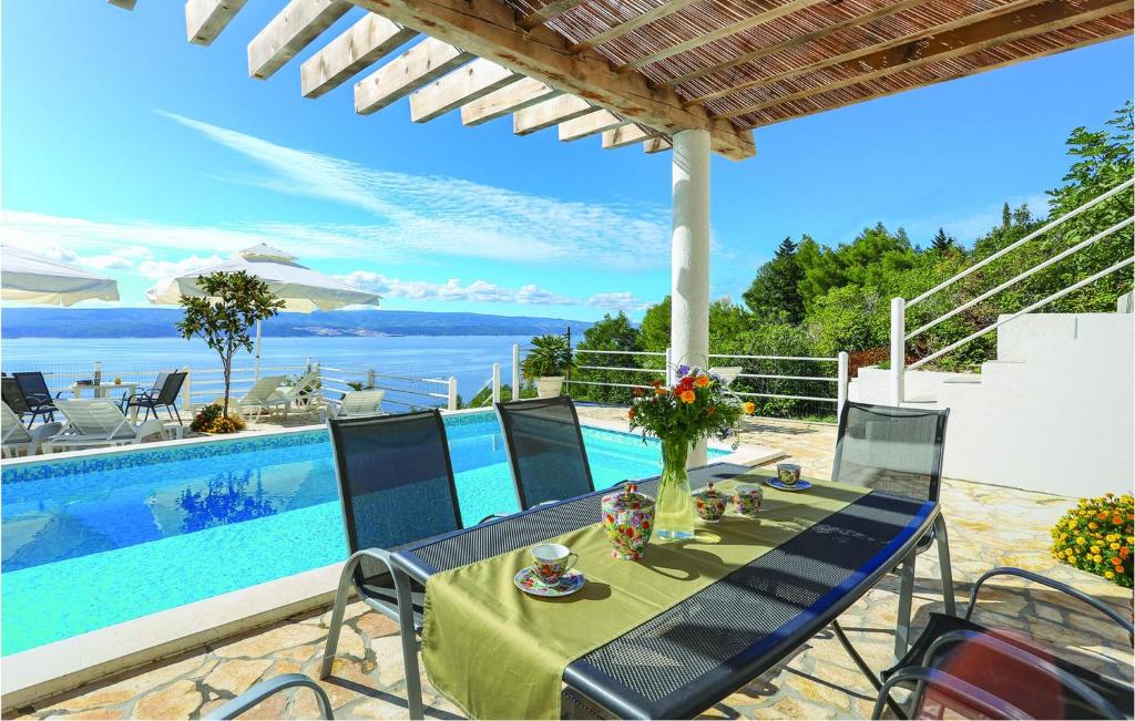 a patio with a table and chairs next to a pool at Apartment Mimice Mimice Brig Iii in Mimice