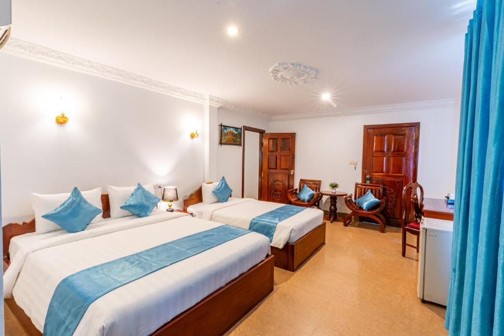 Postel nebo postele na pokoji v ubytování Rithy Rin Angkor Hotel