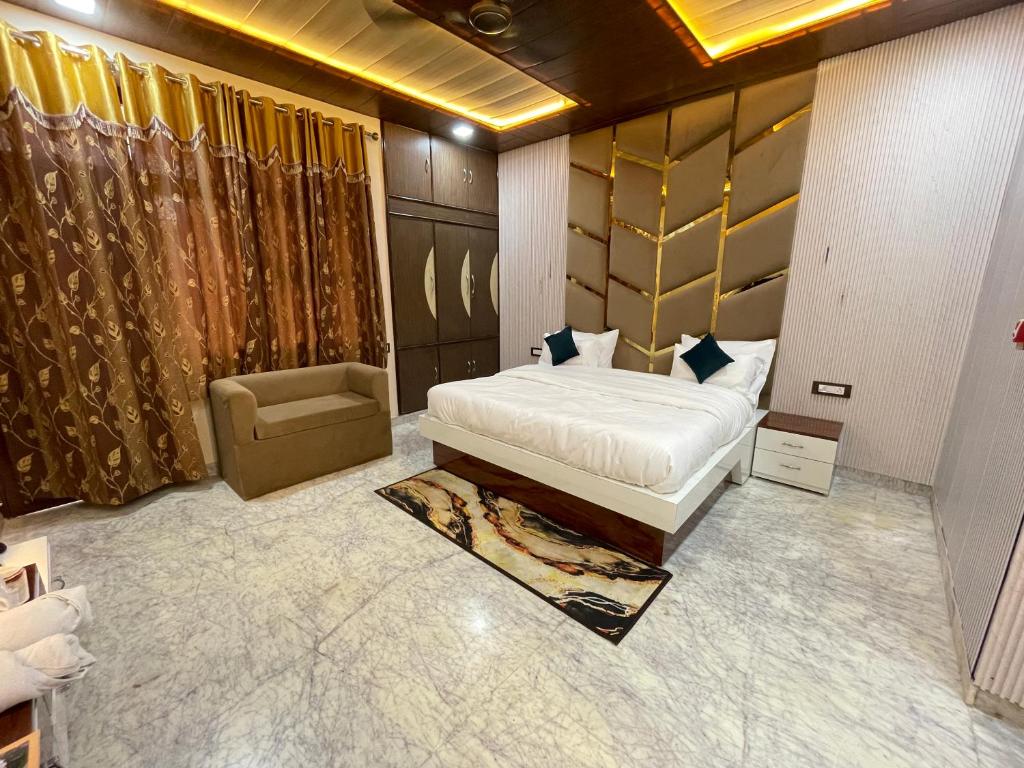 a bedroom with a bed and a chair in it at The Marigold Bliss in Agra