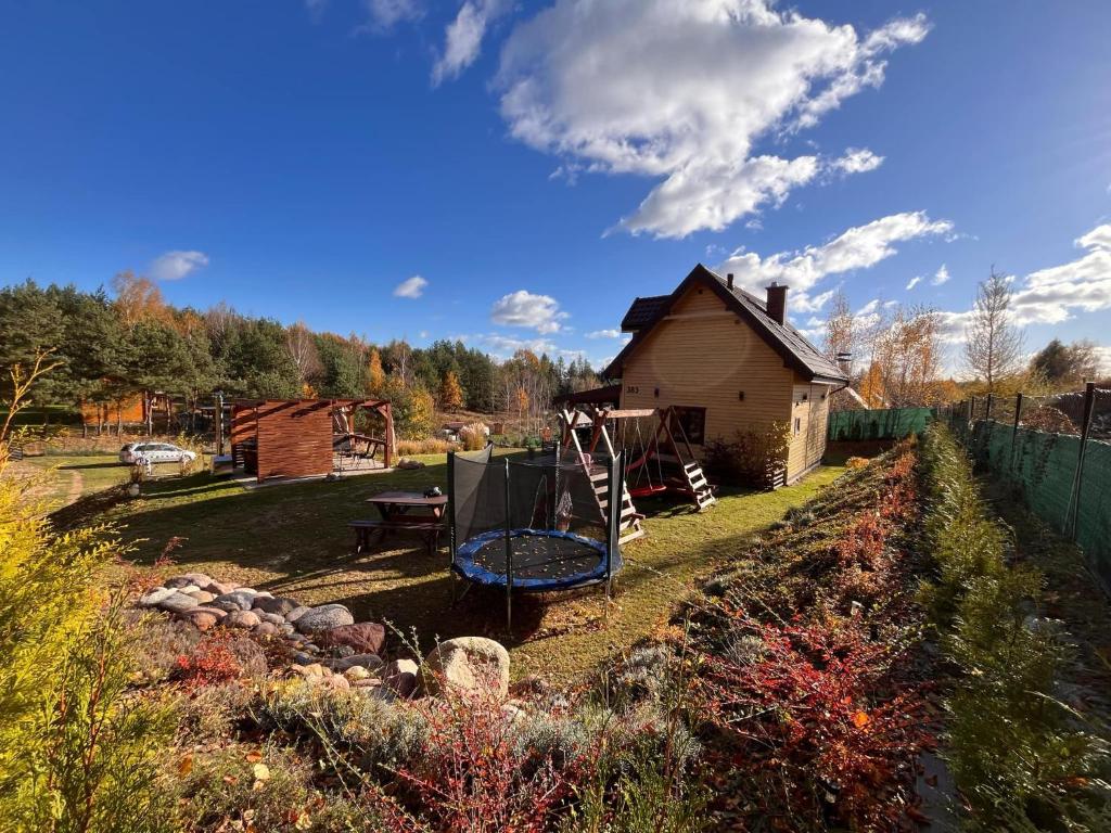 a garden with a house and a playground at Domek pod Dębami Bogaczewo in Bogaczewo