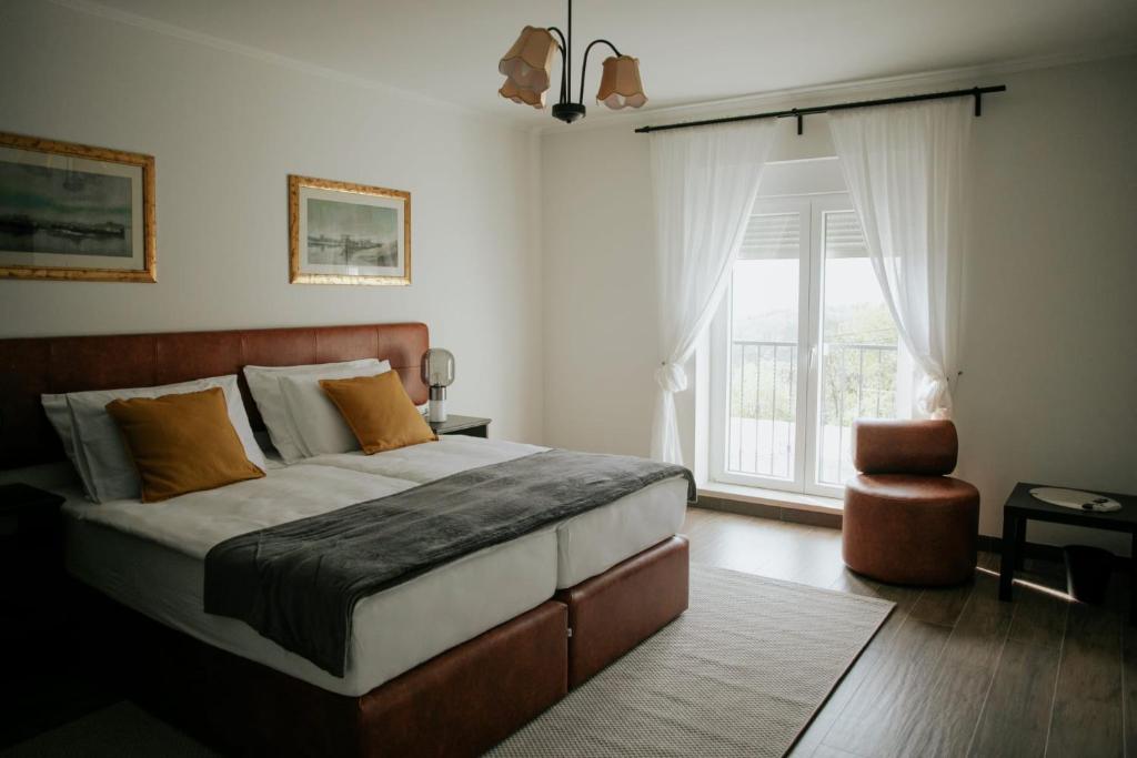 a bedroom with a large bed and a large window at Vila Slavonika in Slavonski Brod