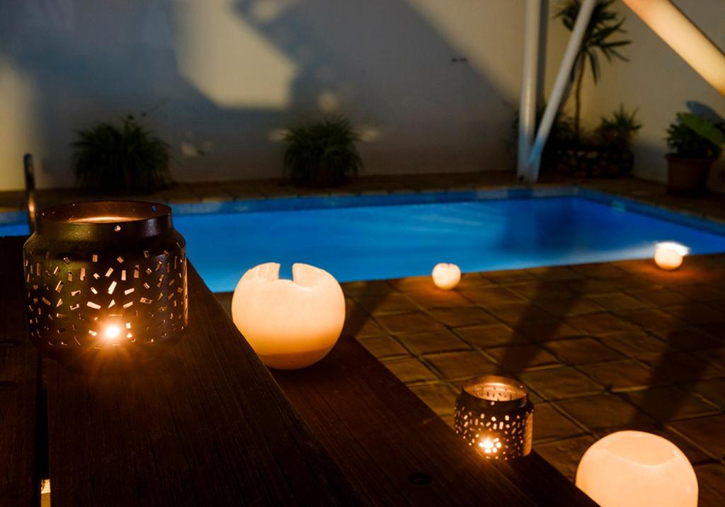 a swimming pool with lights and a table with candles at miKasa Agua Amarga & SPA in Agua Amarga