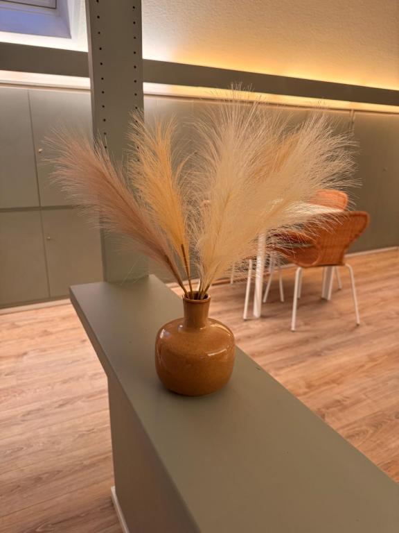 a vase with feathers in it sitting on a table at Ruhrtraum Kettwig Ferienwohnung am Fluss in Essen