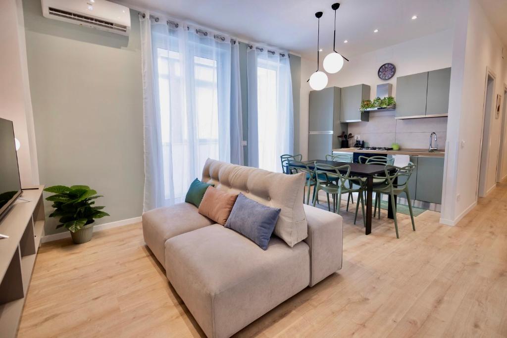 a living room with a couch and a dining room at Politeama Charming Apartment in Palermo