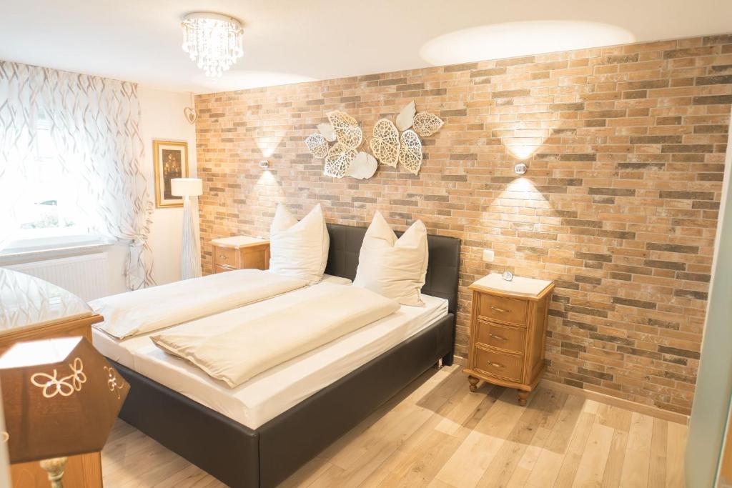 a bedroom with a bed and a brick wall at Elas Ferienhaus in Schleiden