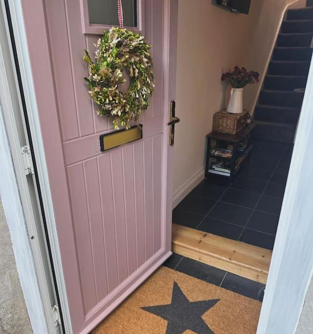 a pink door with a wreath on top of it at Love Lane Cottage Dolgellau in Dolgellau