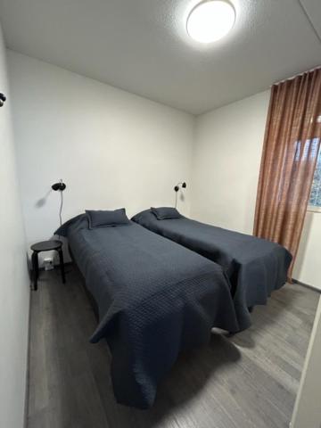 a bedroom with two beds with black comforters at Arctic Hill Apartment Ylläs in Ylläs