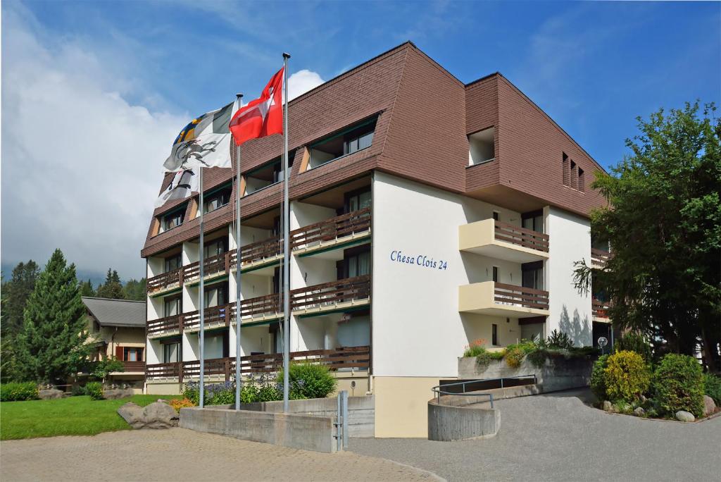 a hotel with two canadian flags in front of it at Ferienwohnungen Chesa Clois 24 Studios in Lenzerheide