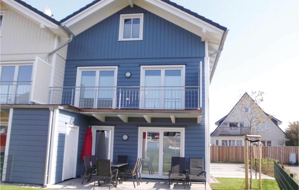 a blue house with a table and chairs at Stunning Home In Dagebüll With Sauna in Dagebüll