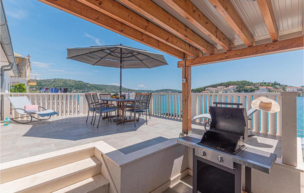 een patio met een tafel en een parasol op een terras bij Gorgeous Home In Rogoznica in Rogoznica