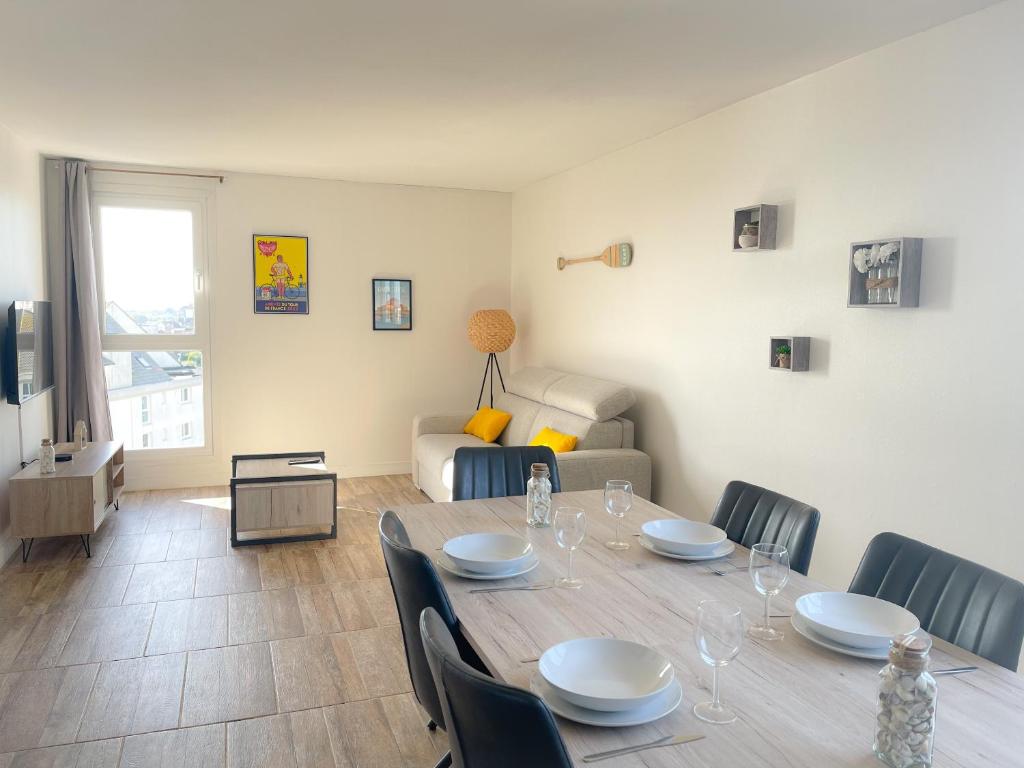 une table à manger et des chaises dans un salon dans l'établissement L'Horizon, à Calais
