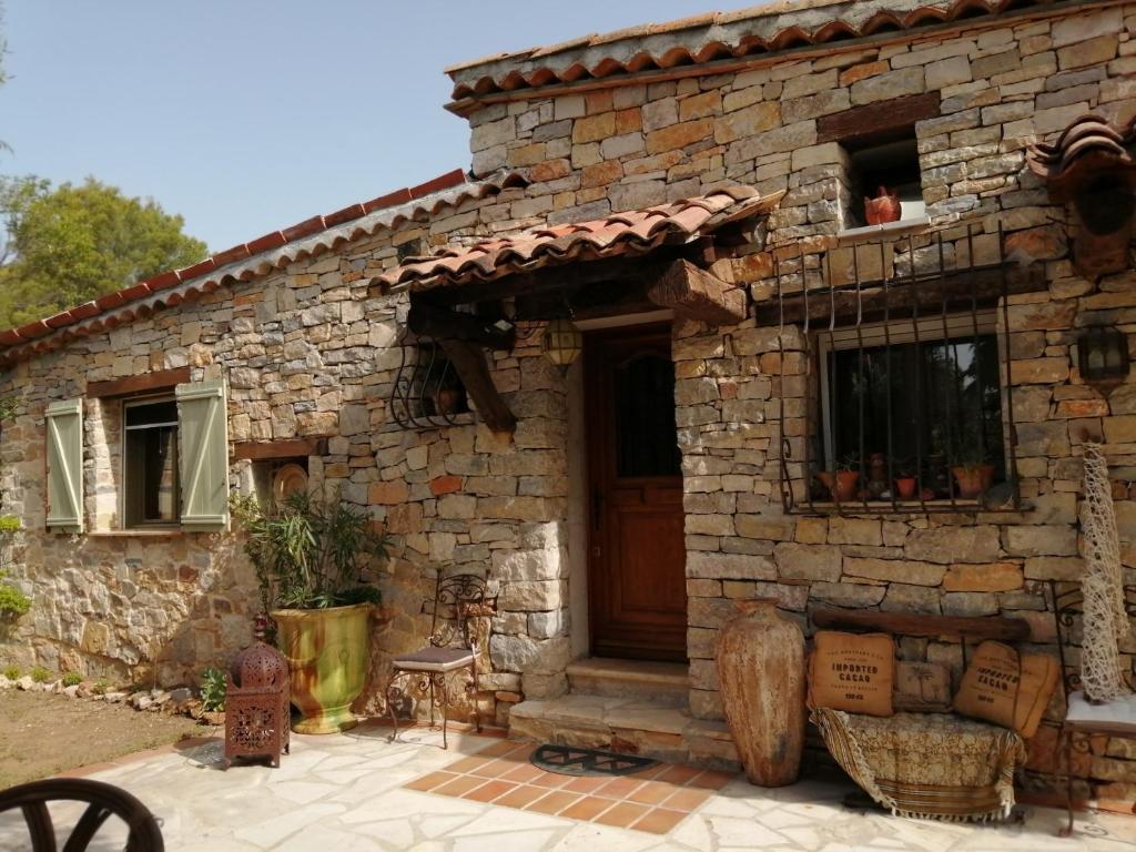 une maison en pierre avec une porte et une terrasse couverte dans l'établissement Lou Masou, à Flayosc
