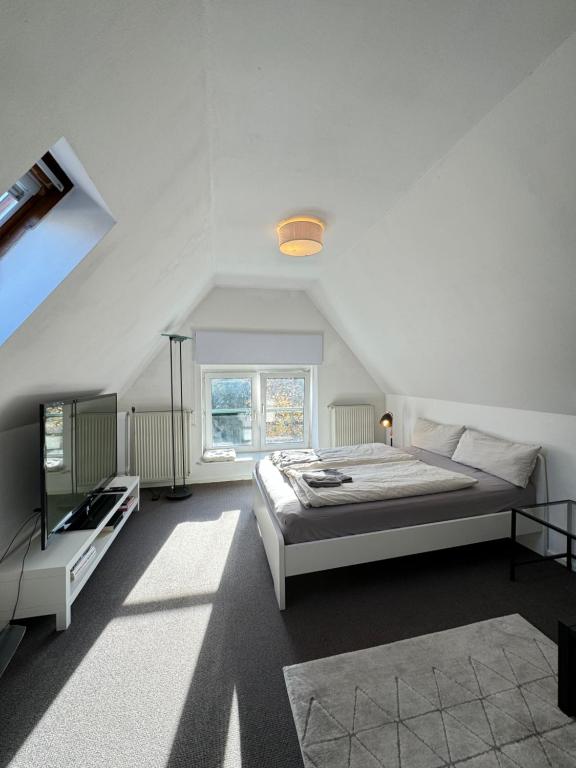 Hotel Appartment im DG Berlin / 5 min zur Messe, a white bedroom with a bed and a window at Appartment im DG Berlin / 5 min zur Messe in Berlin