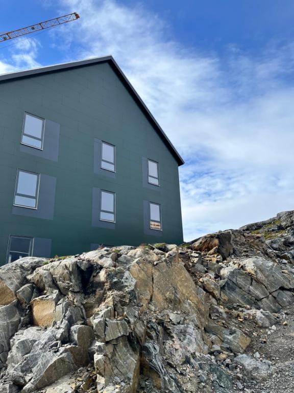 a building on top of a rocky hill at ATCON Business Apartments in Nuuk