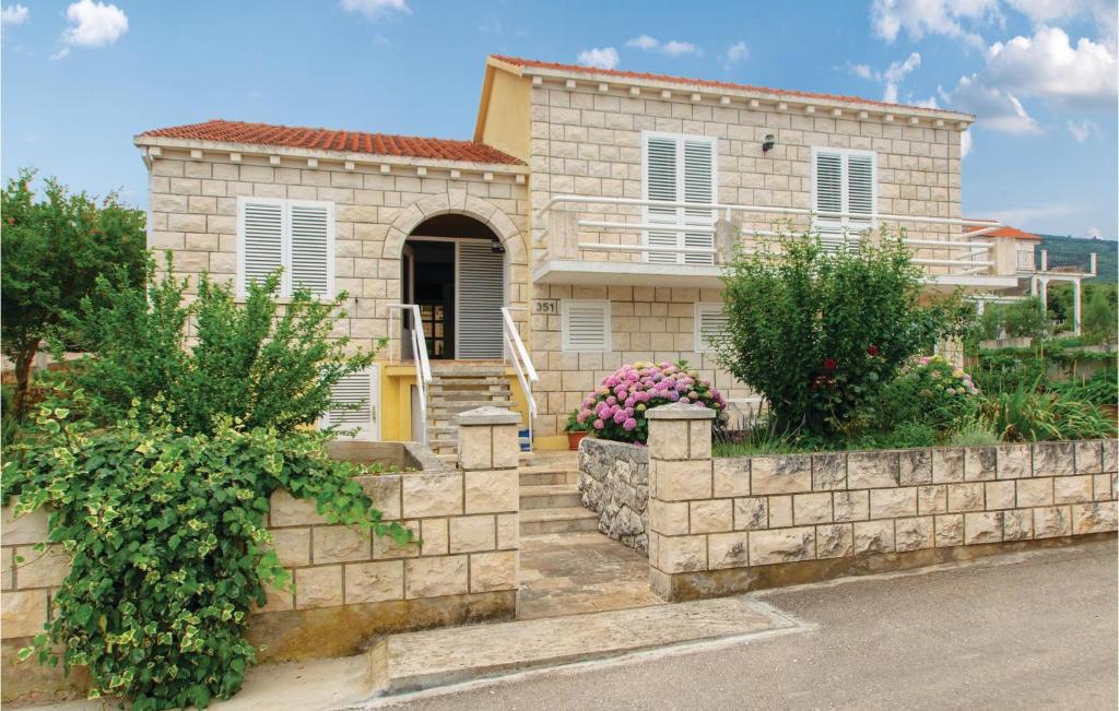 a house with a stone fence in front of it at Two-Bedroom Apartment In Racisce in Račišće