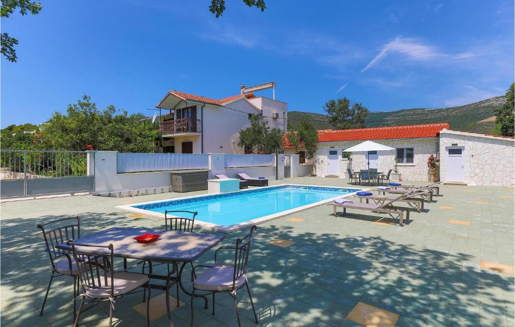a patio with a table and chairs next to a swimming pool at Cozy Apartment In Kastel Novi in Kastel Novi