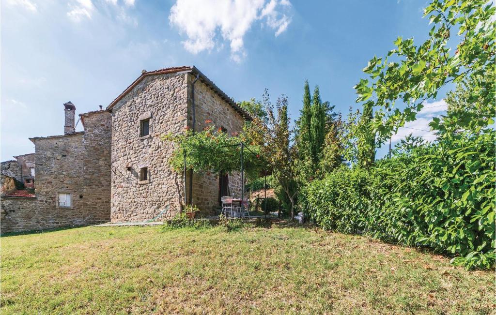stary ceglany budynek na trawiastym polu w obiekcie Casa Ginestra w mieście Poggioni