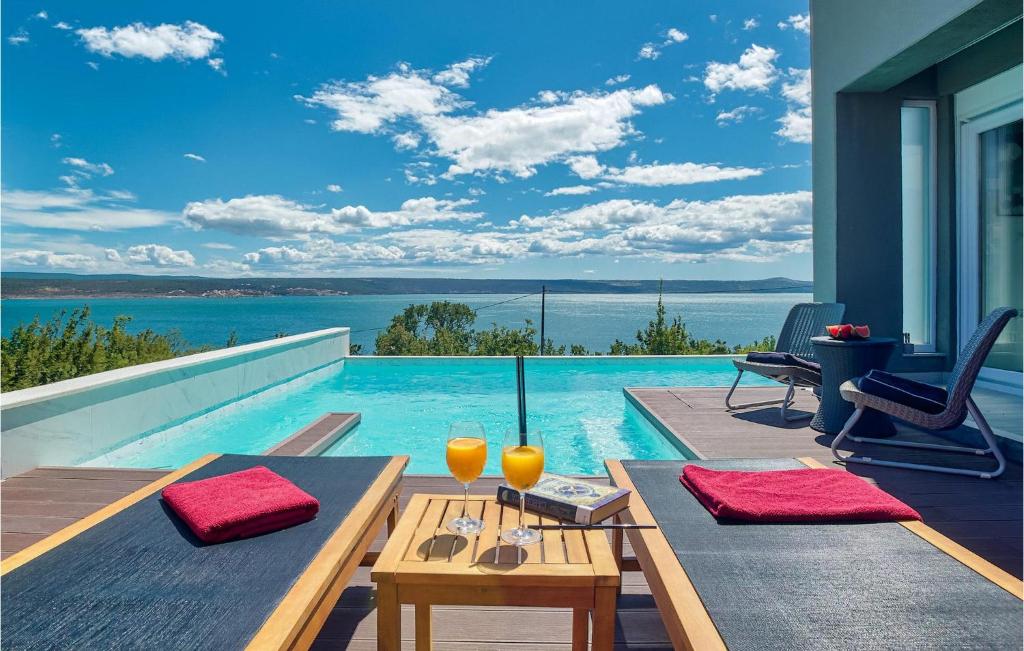 a pool with a table and two glasses on it at Villa Amy in Zadar