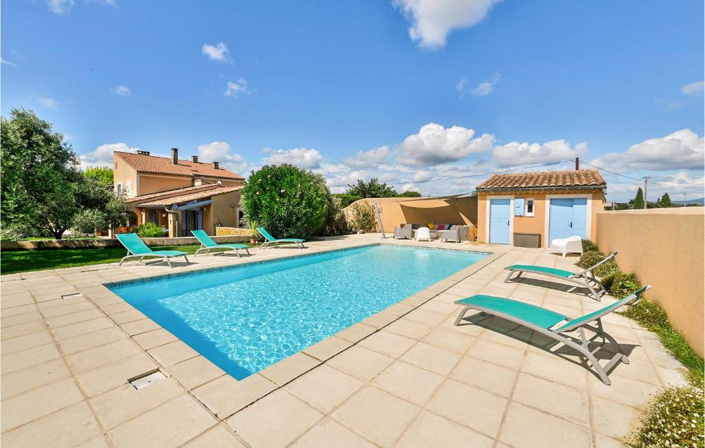 a swimming pool with lounge chairs and a house at Beautiful Home In Valréas in Valréas