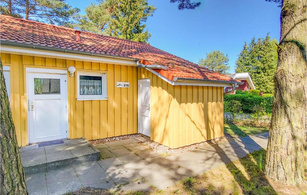 ein kleines gelbes Haus mit weißer Tür in der Unterkunft Amazing Home In Mirow Ot Granzow in Granzow